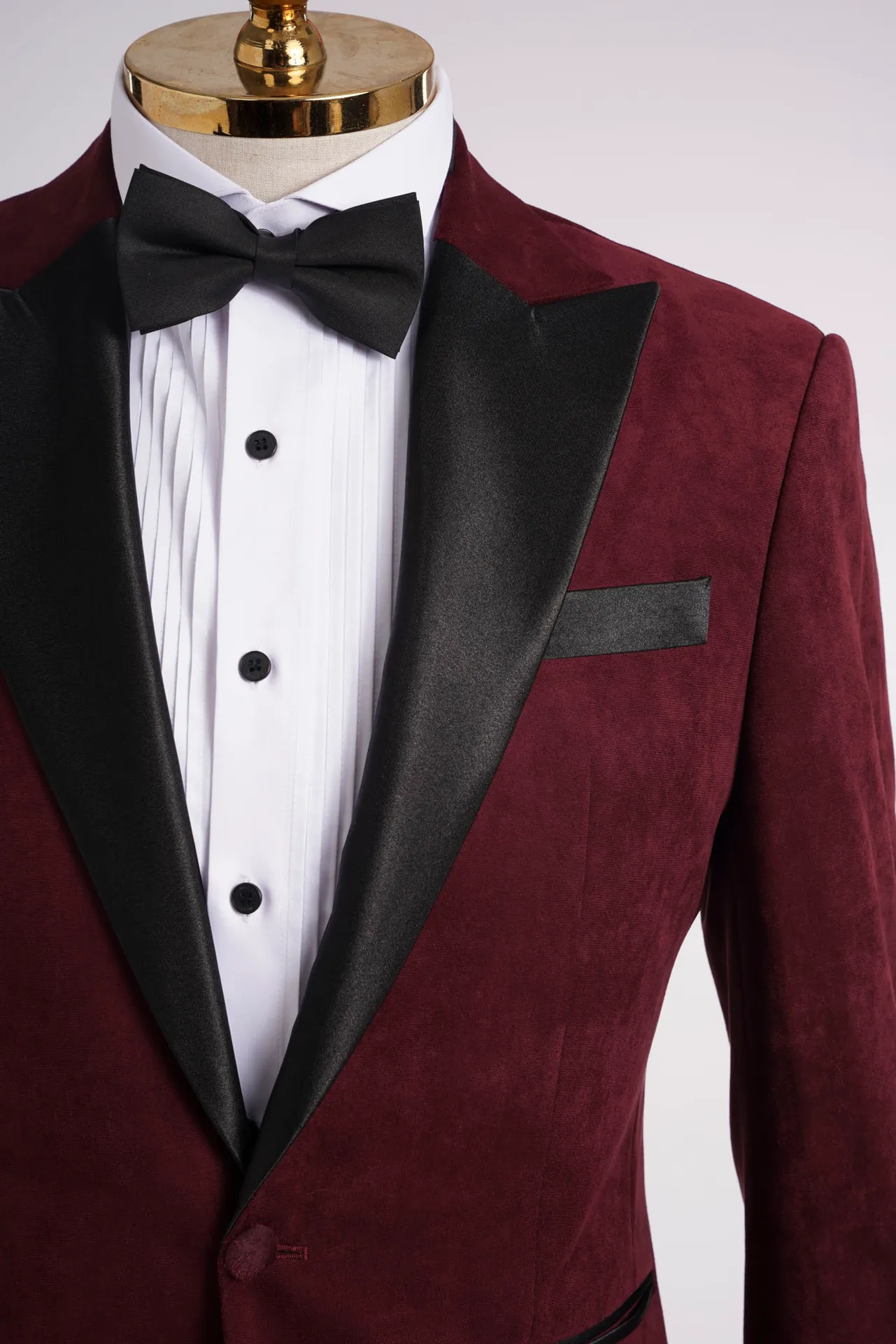 Cận cảnh cổ ve satin đen của tuxedo nhung đỏ đô, sơ mi trắng và nơ đen